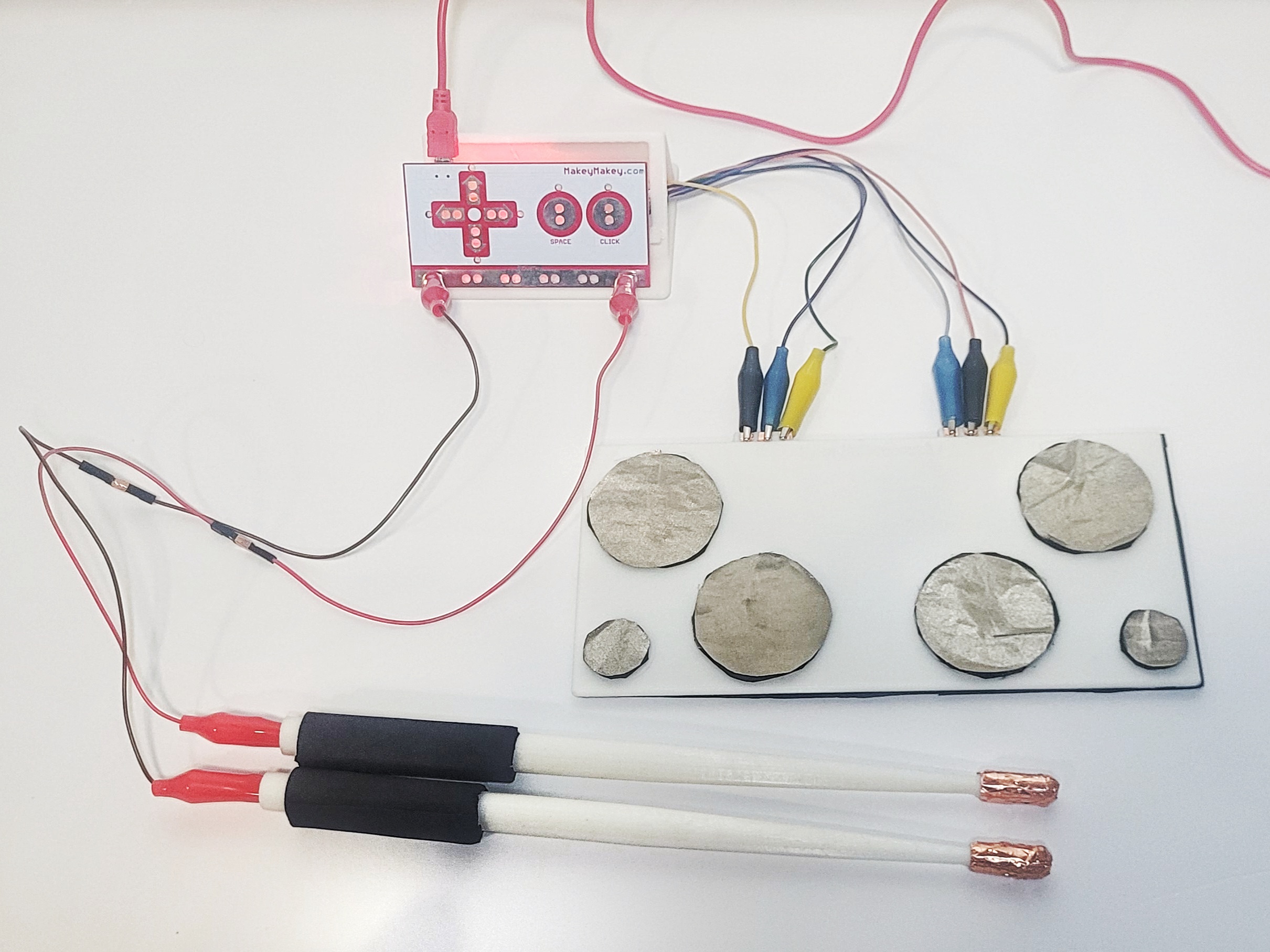 Image of the full 3D printed drumkit, drumsticks, stand, and MakeyMakey